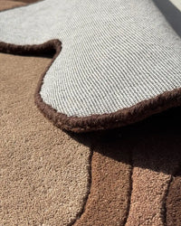 Irregular-shaped brown wool rug with tonal shading, boutique novelty rug for eclectic or boho spaces