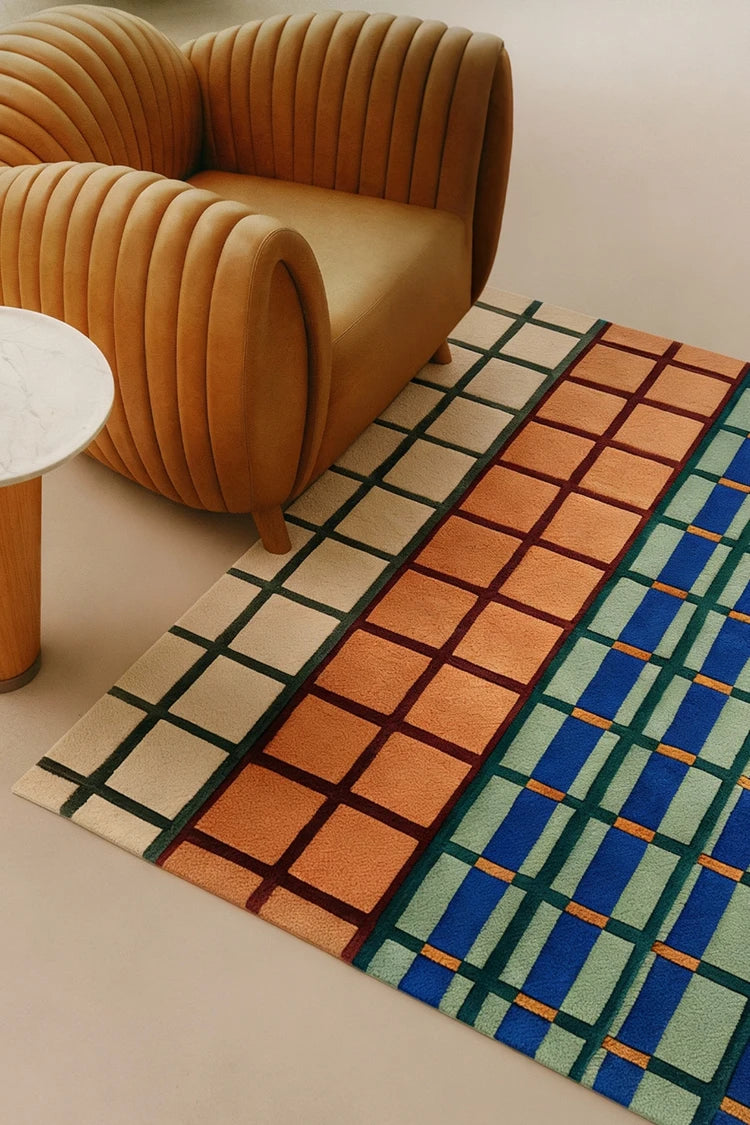 Patterned rug with geometric design on a light-colored floor, featuring a brown armchair.