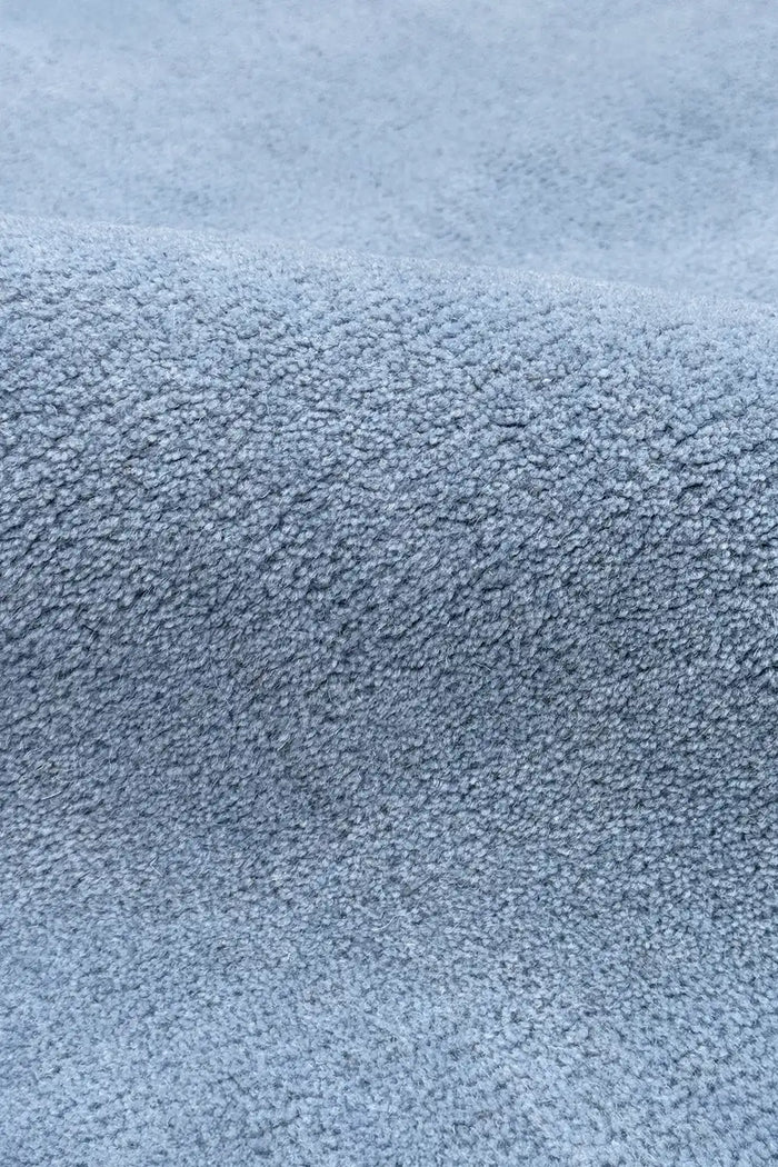 Close-up of a wool textured light baby blue tufted rug