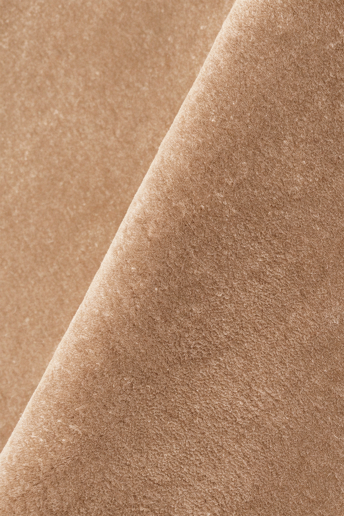 close up texture of a tan light brown hand tufted wool rug