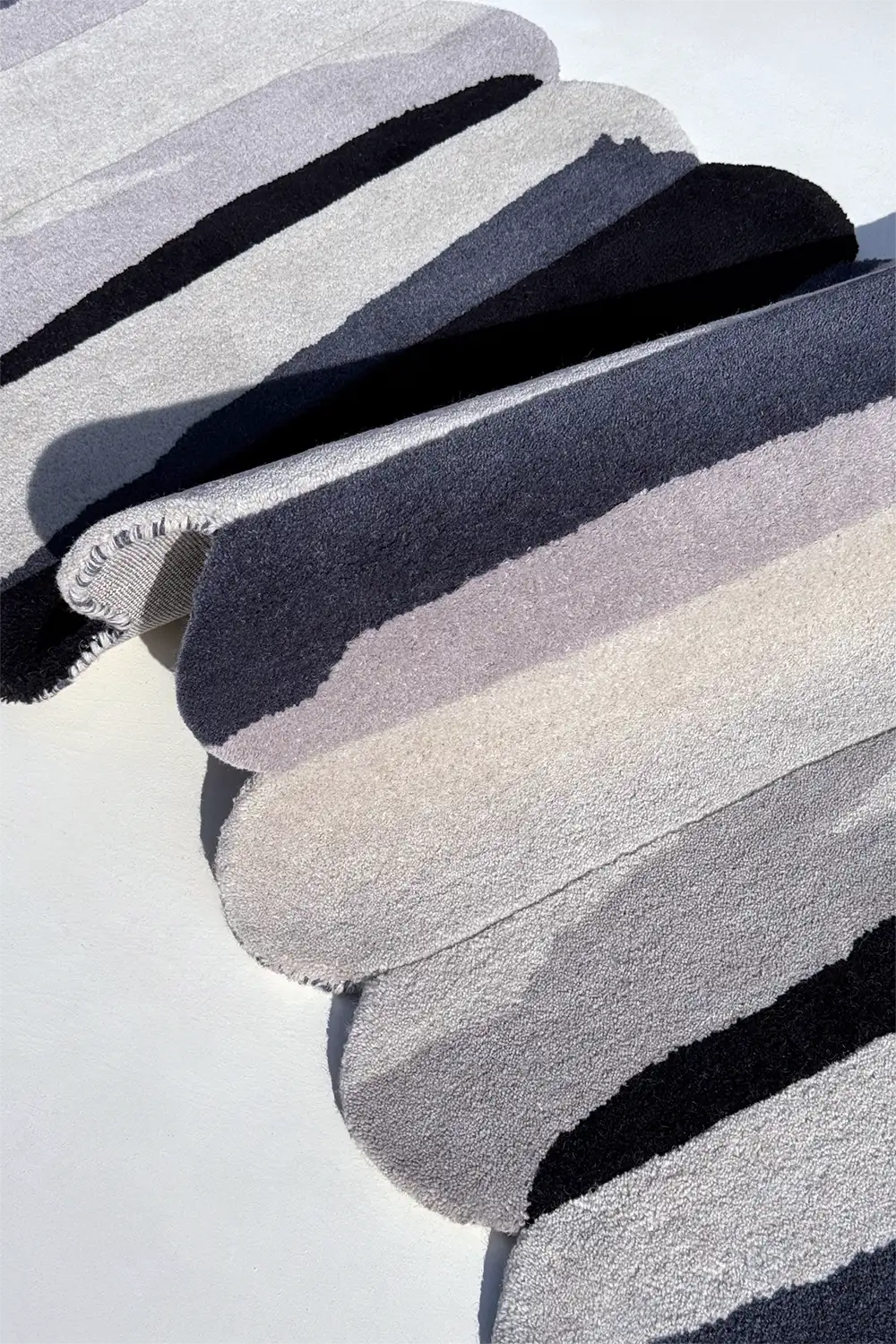scalloped wool runner rug with stacked bands of silver gray and black