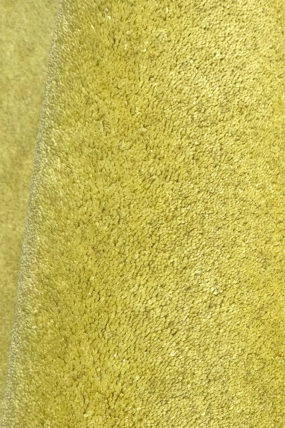 close-up texture of yellow green hand tufted wool area rug