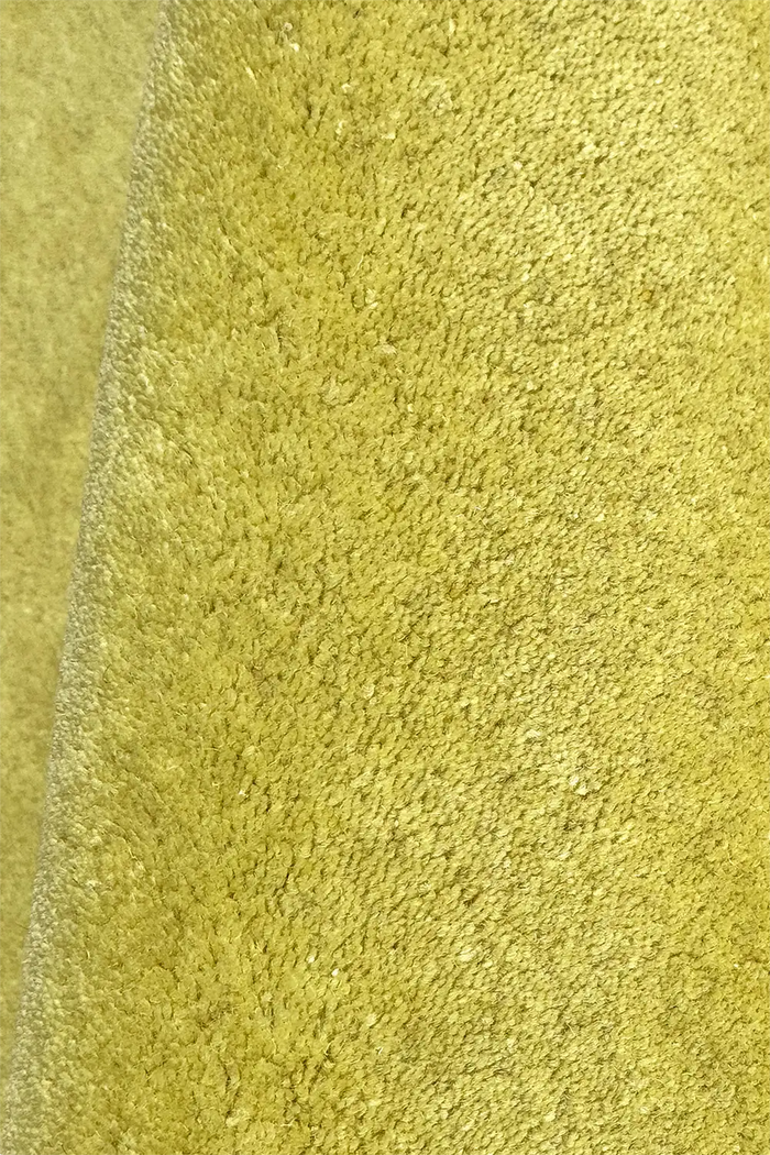 close-up texture of yellow green hand tufted wool area rug