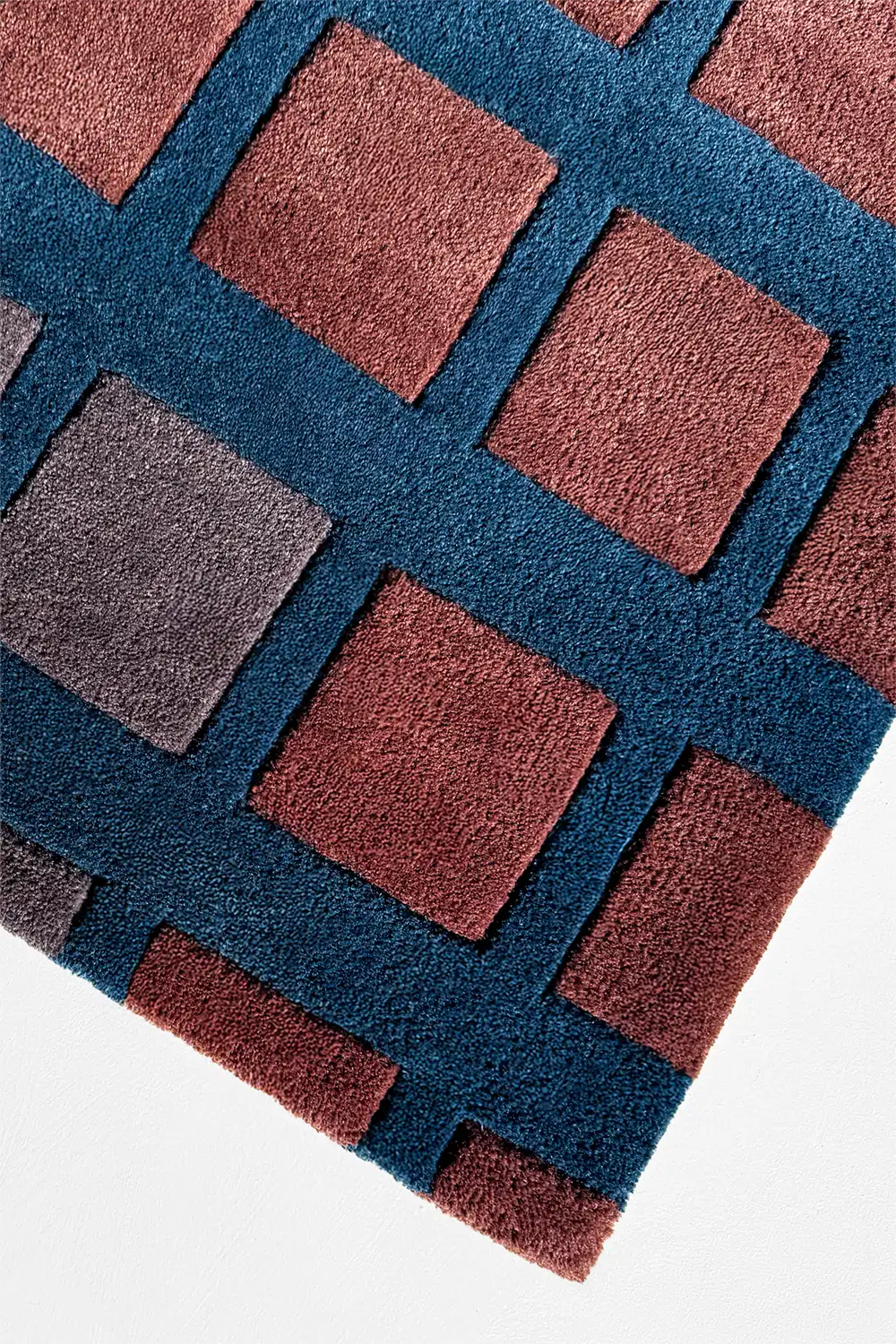 Close-up of a textured rug with geometric pattern on a white background