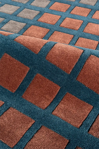 Close-up of a textured rug with brown and blue square patterns