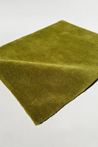 modern olive green rug on a light gray background