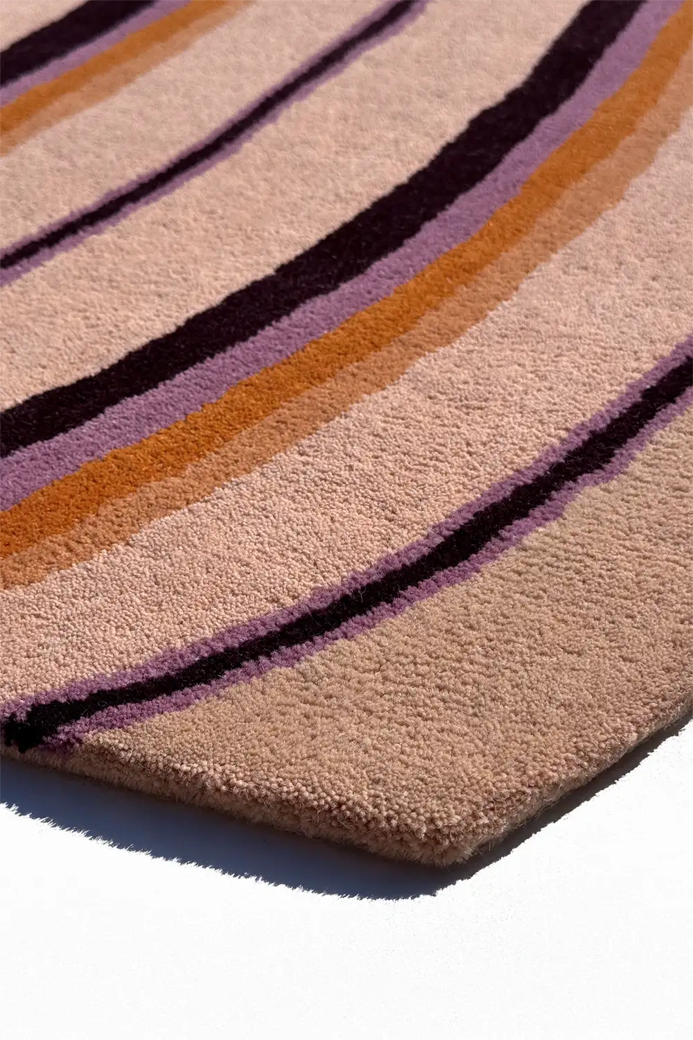 Close-up of a textured rug with multicolored stripes on a white background