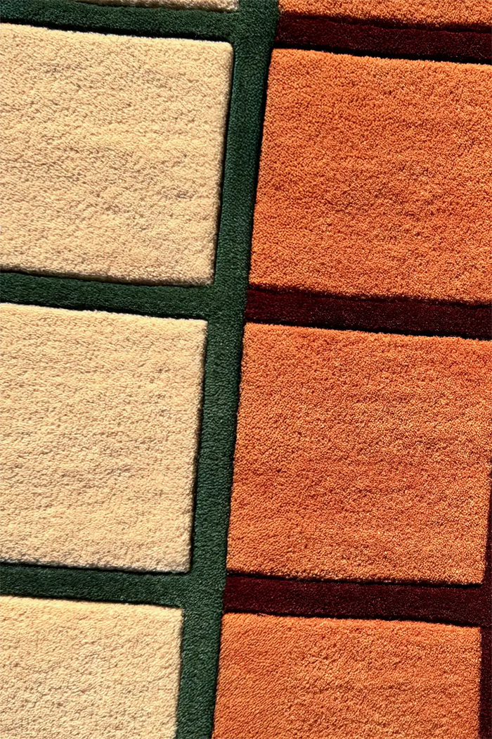 Close-up of a multicolor runner rug with square patterns in beige, orange, and green.