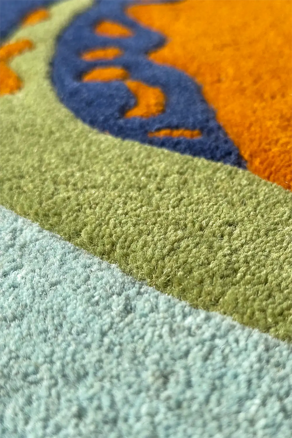 Wool oval rug with sculpted details and bold colors, featuring a playful organic shape and textured surface