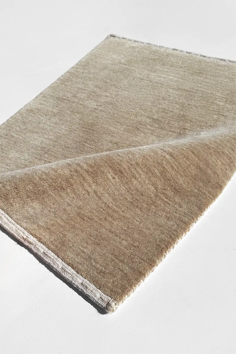 Textured cream taupe rug on a light gray background