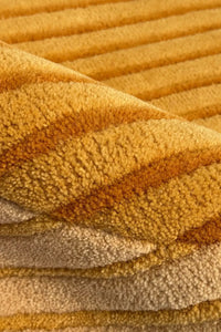 Close-up of textured yellow gold and tan modern wool area rug 8x10