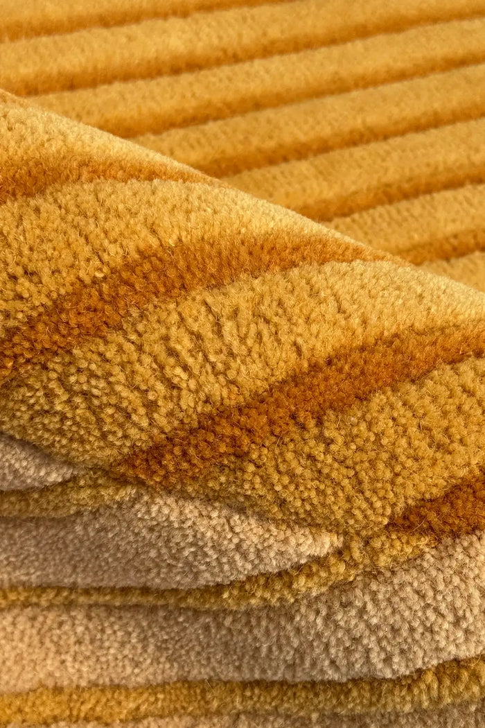 Close-up of textured yellow gold and tan modern wool area rug 8x10