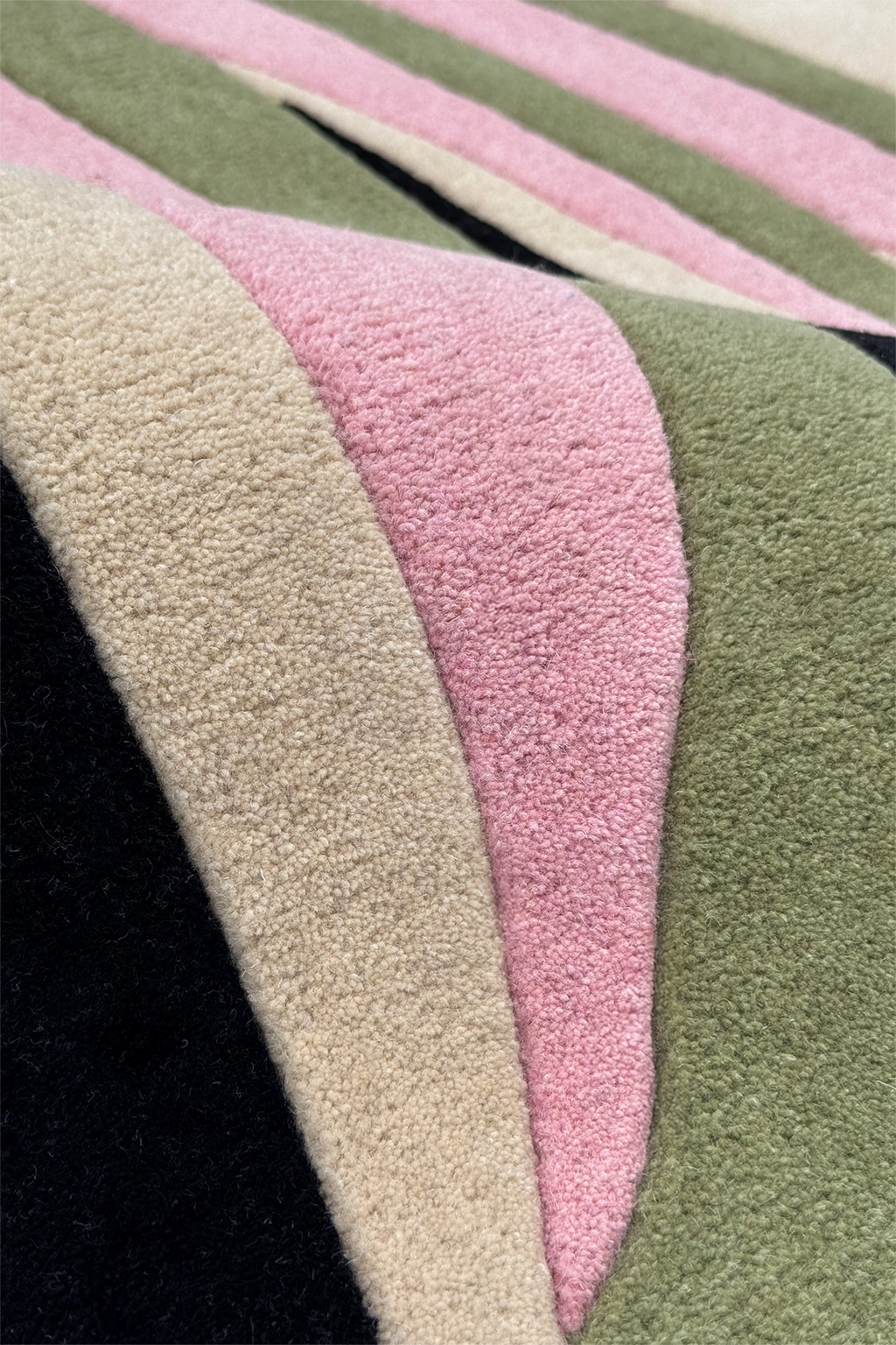 Close-up of a textured rug with pink and green stripes on a black background multicolor texture