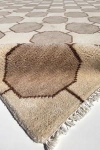 octagonal patterned wool rug with fringe on a tiled floor ivory