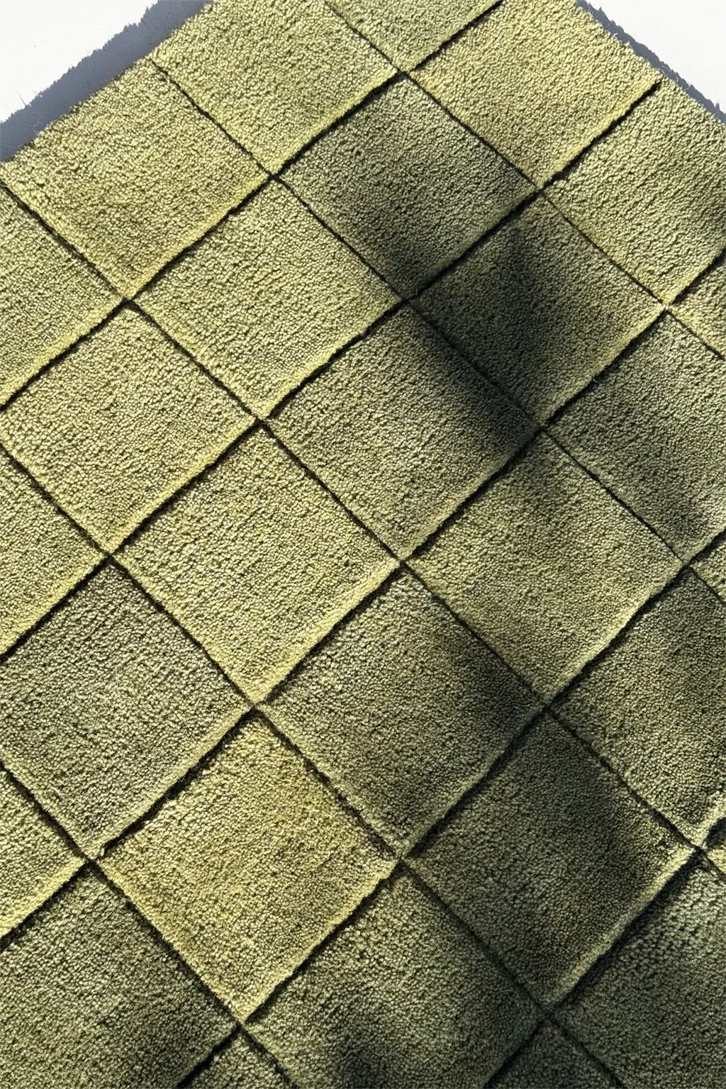 Close-up of green checkered wool rug surface