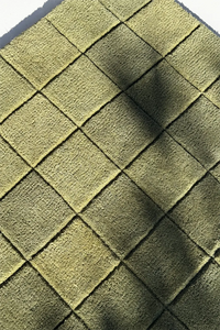 Close-up of green checkered wool rug surface