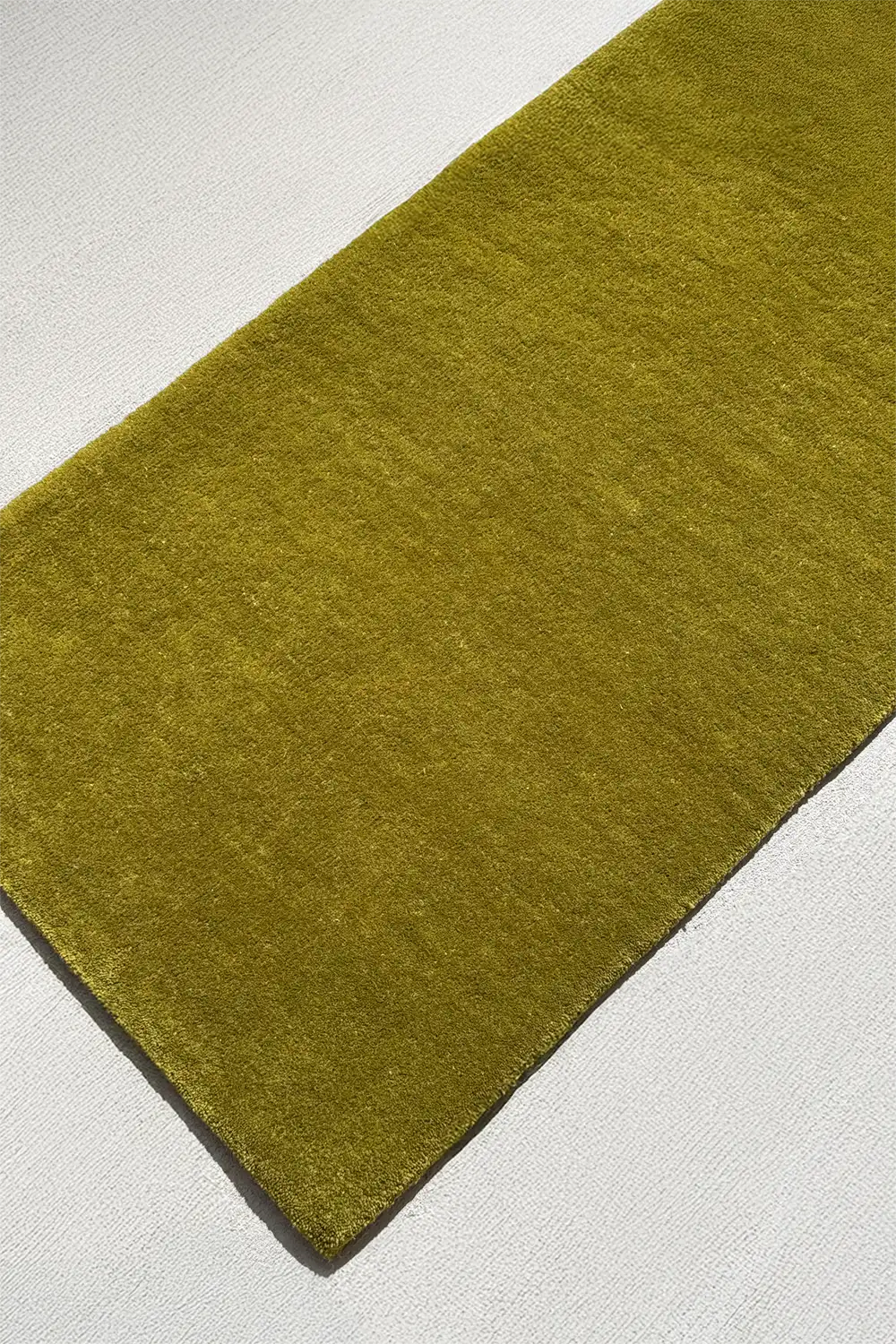 Green wool runner rug on a white background