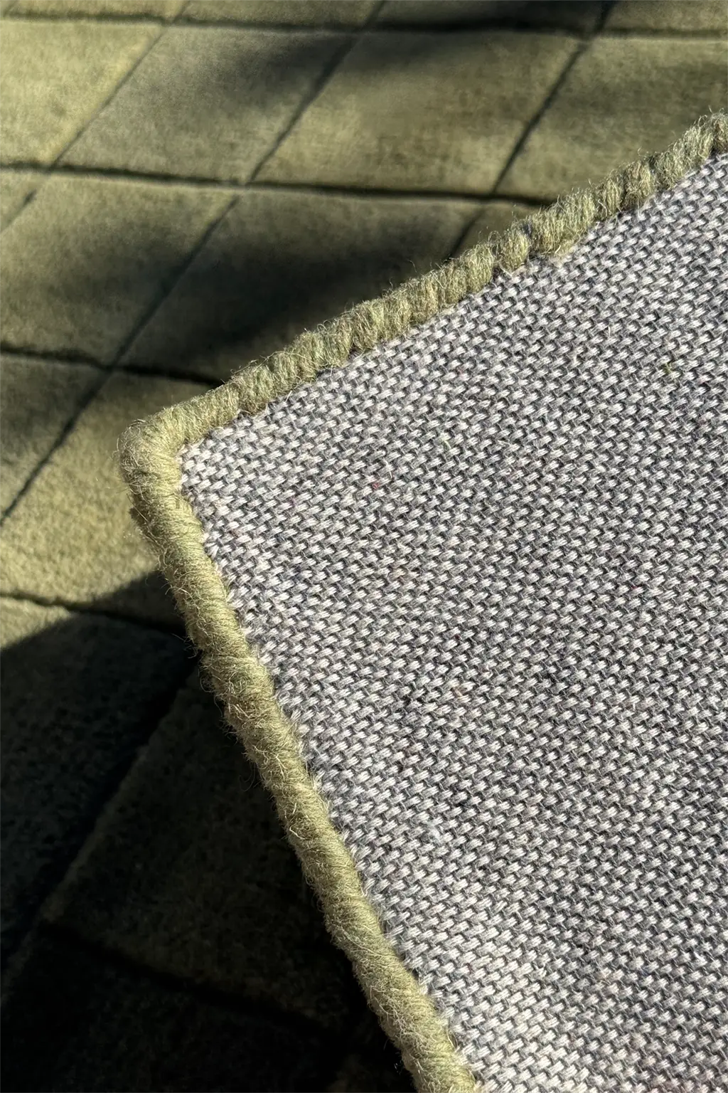 Close-up of textured square rug with a grid pattern