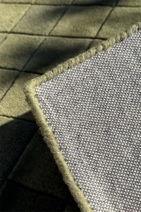 Close-up of textured square rug with a grid pattern