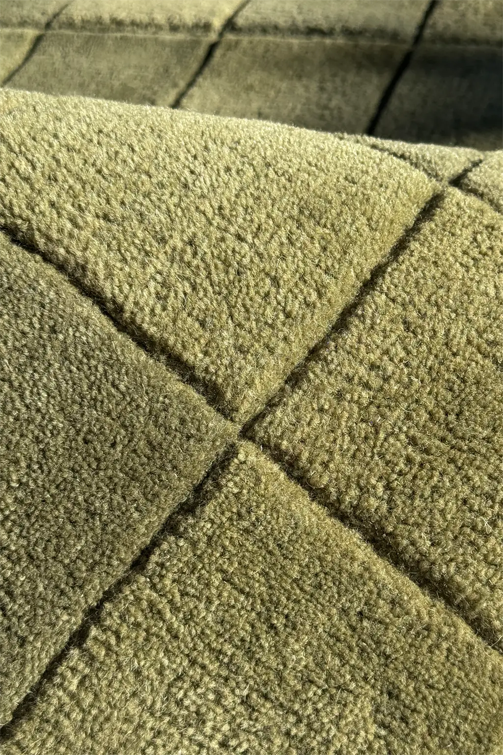Close-up of green checkered wool rug in olive tones