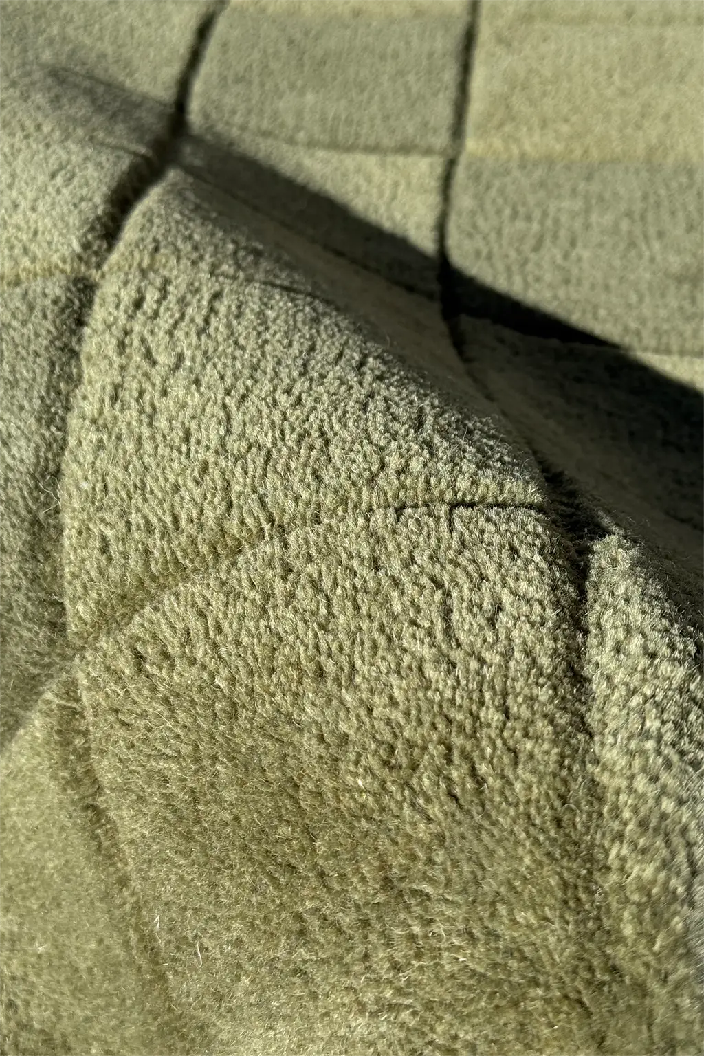 Close-up of a wool green runner rug surface