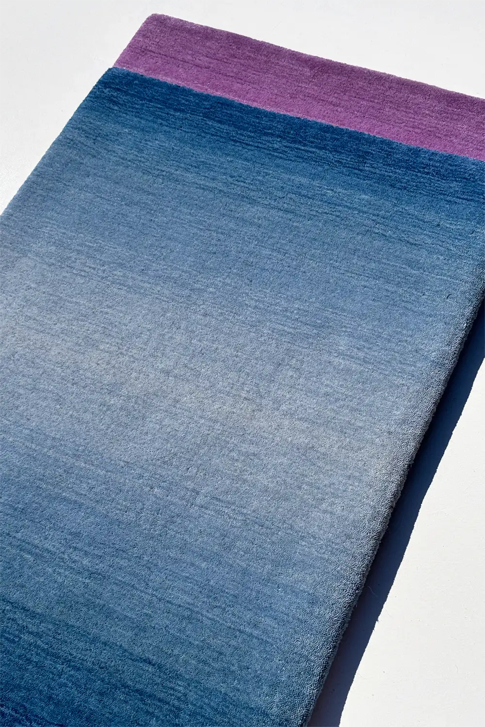 colorful blue and purple gradient ombre rugs on a white background