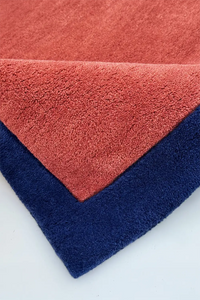 burnt orange square rug hand tufted in wool with deep navy border