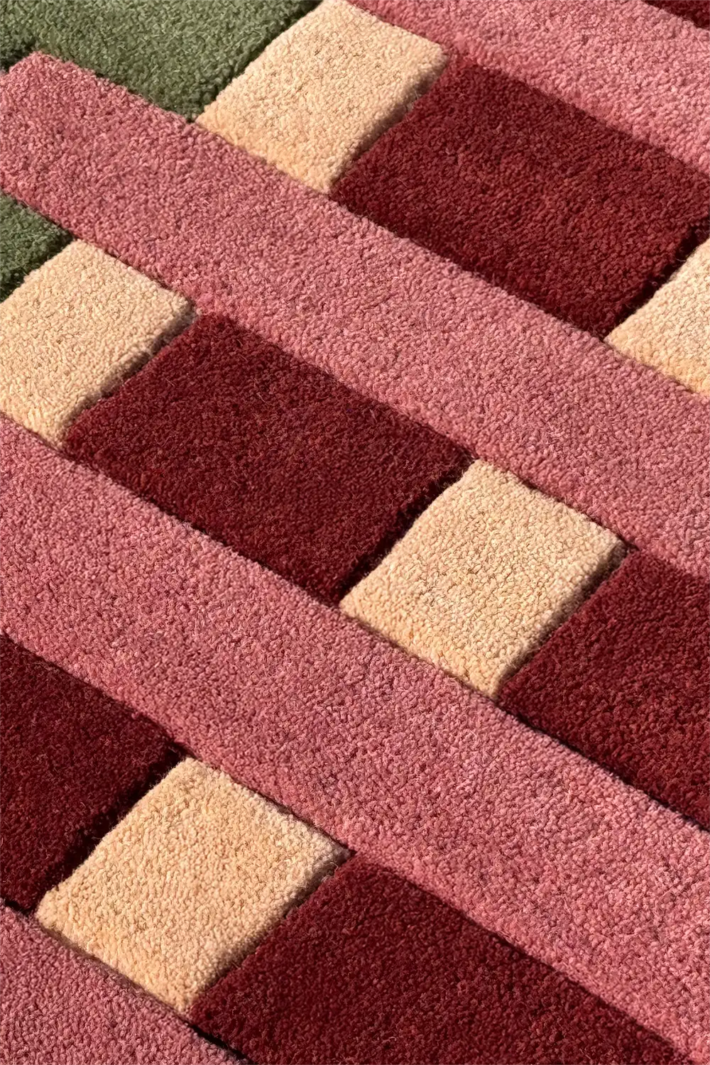 Close-up of a textured rug with geometric striped pattern in red, beige, and green.