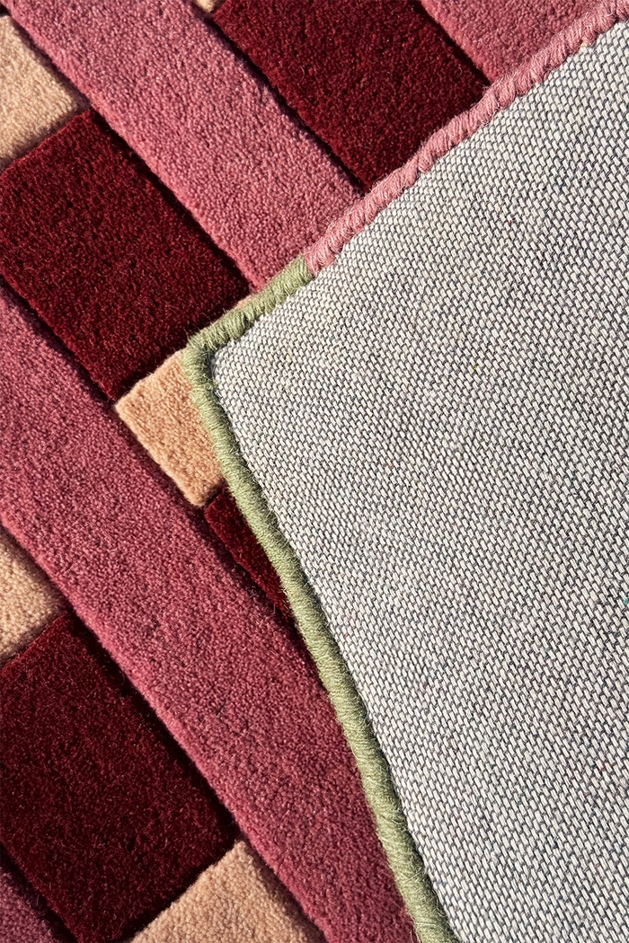 edge binding of a square wool rug with geometric pattern