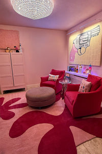 Living room with red furniture, pink rug, and decorative elements lifestyle