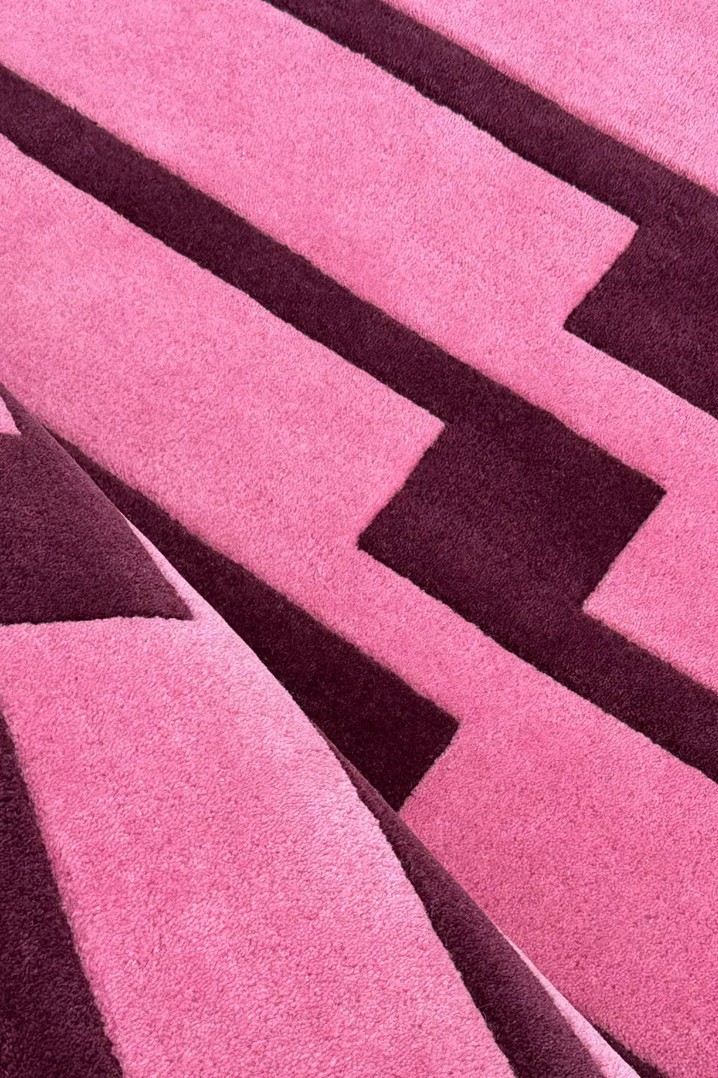 Close-up of a pink and purple geometric patterned runner rug texture
