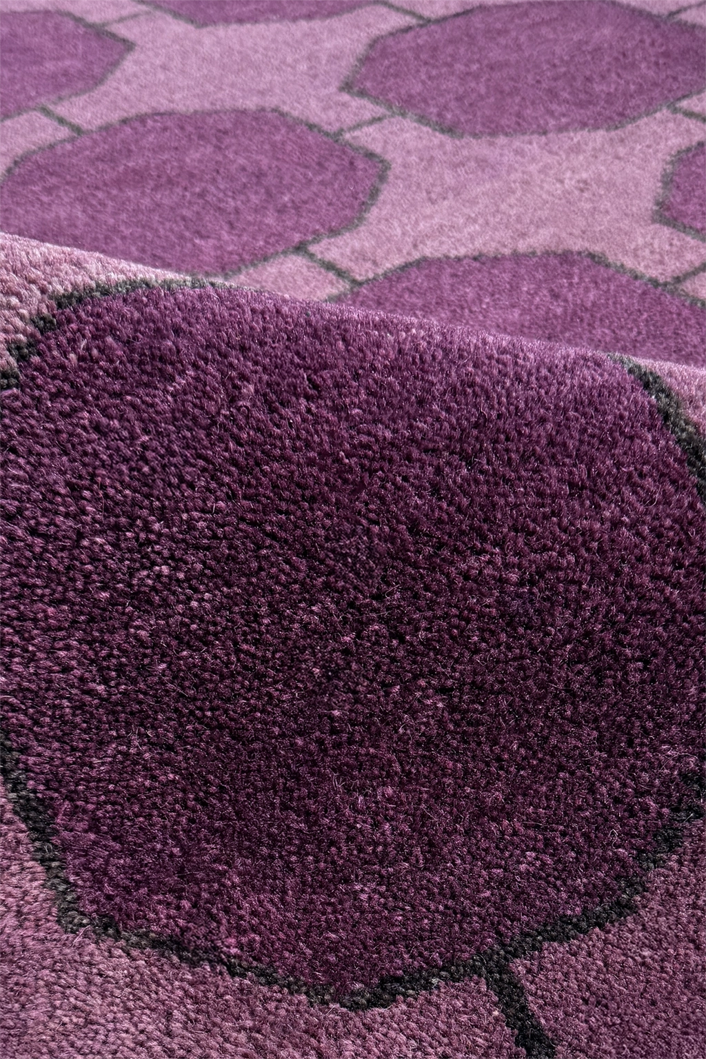 Close-up of a textured purple rug with a geometric pattern