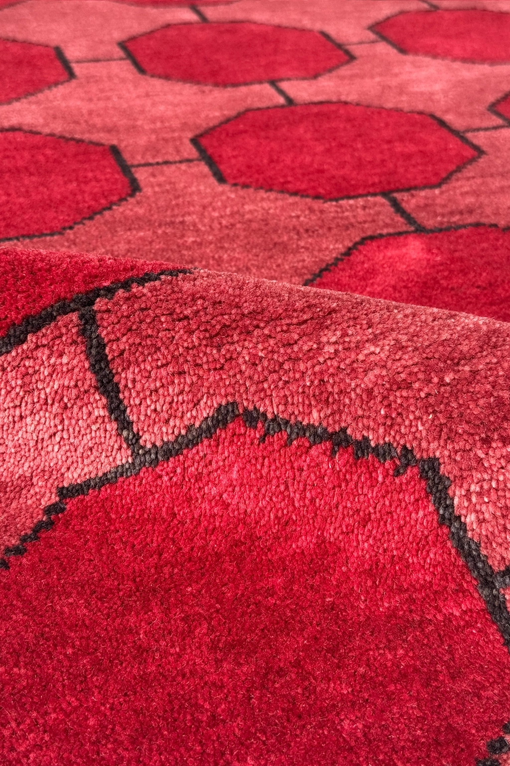 Close-up of a red geometric patterned rug in hand-knotted wool texture