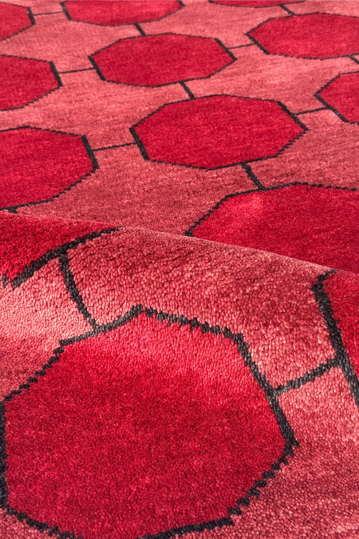 Close-up of a red geometric patterned rug wool texture hand-knotted