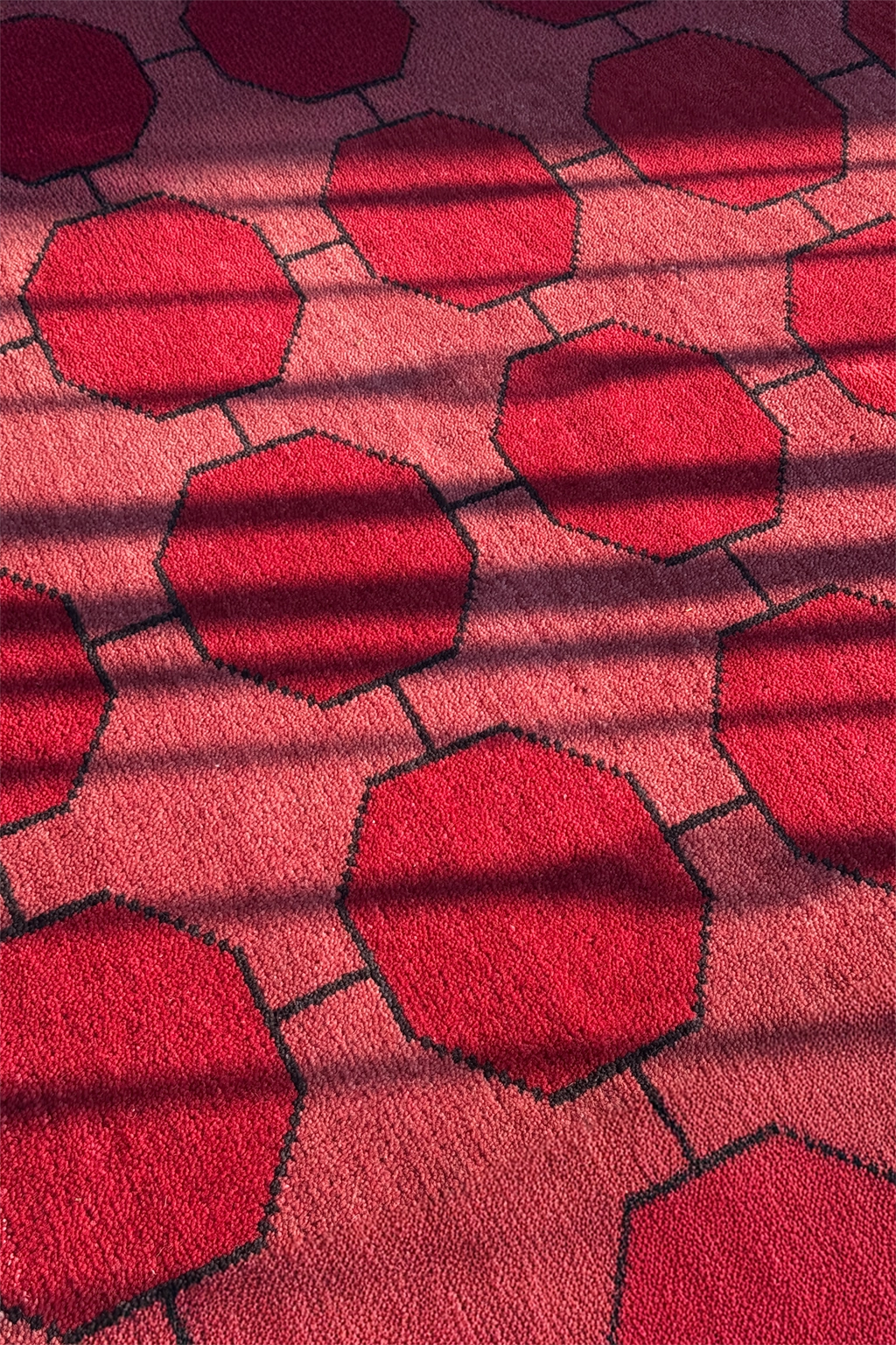 Close-up of a red geometric patterned rug in the sun