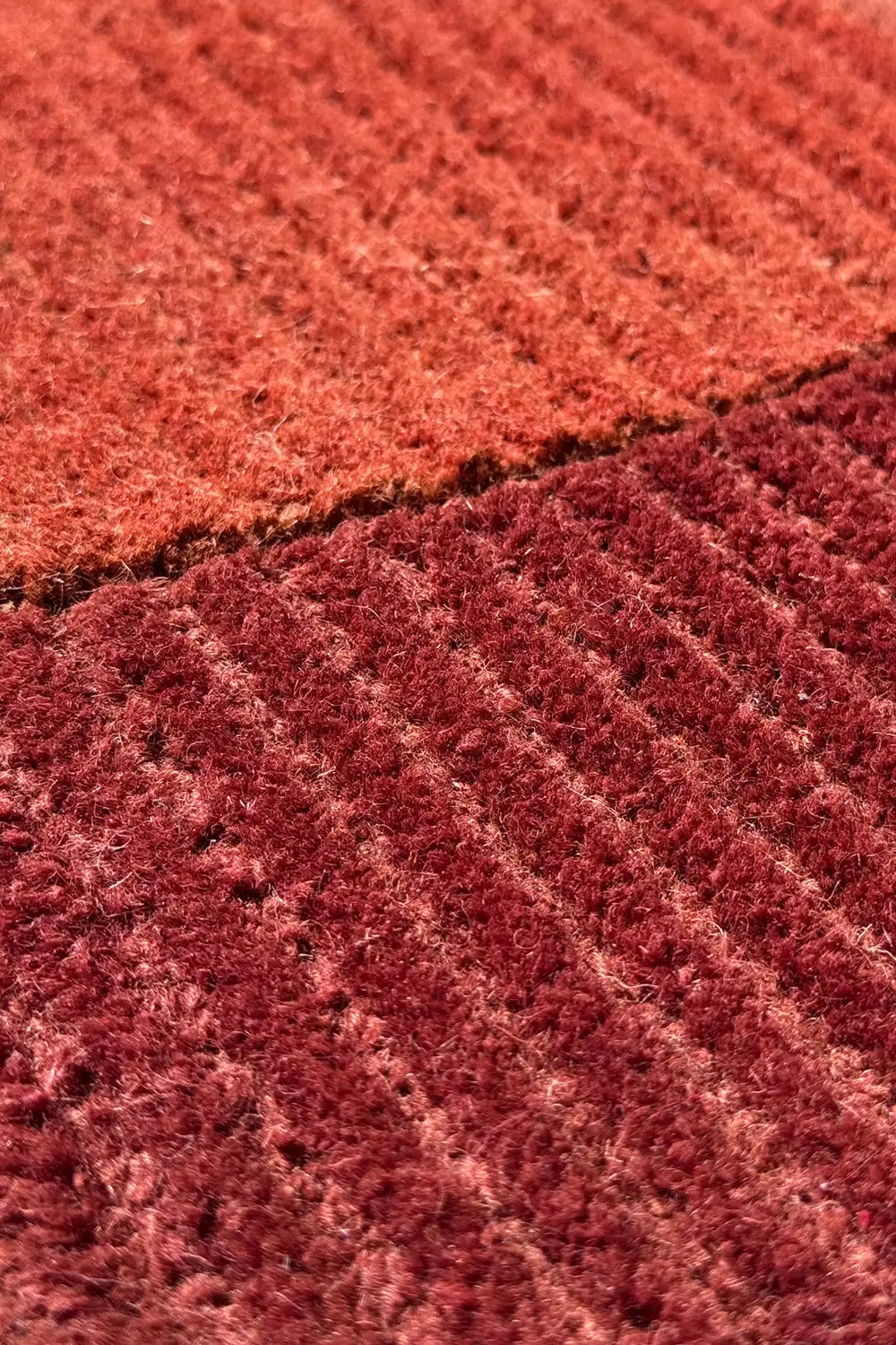 Red and orange wool rug with ridged tufted texture, cozy modern accent for bedroom or office