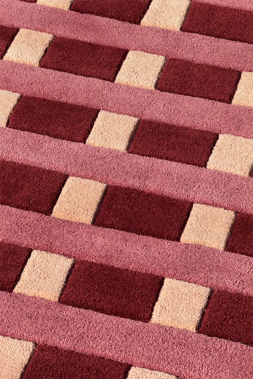 Close-up of a textured red and beige tufted wool modern rug