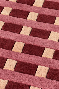 Close-up of a textured red and beige tufted wool modern rug