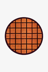 Round orange rug with burgundy grid pattern on a white background