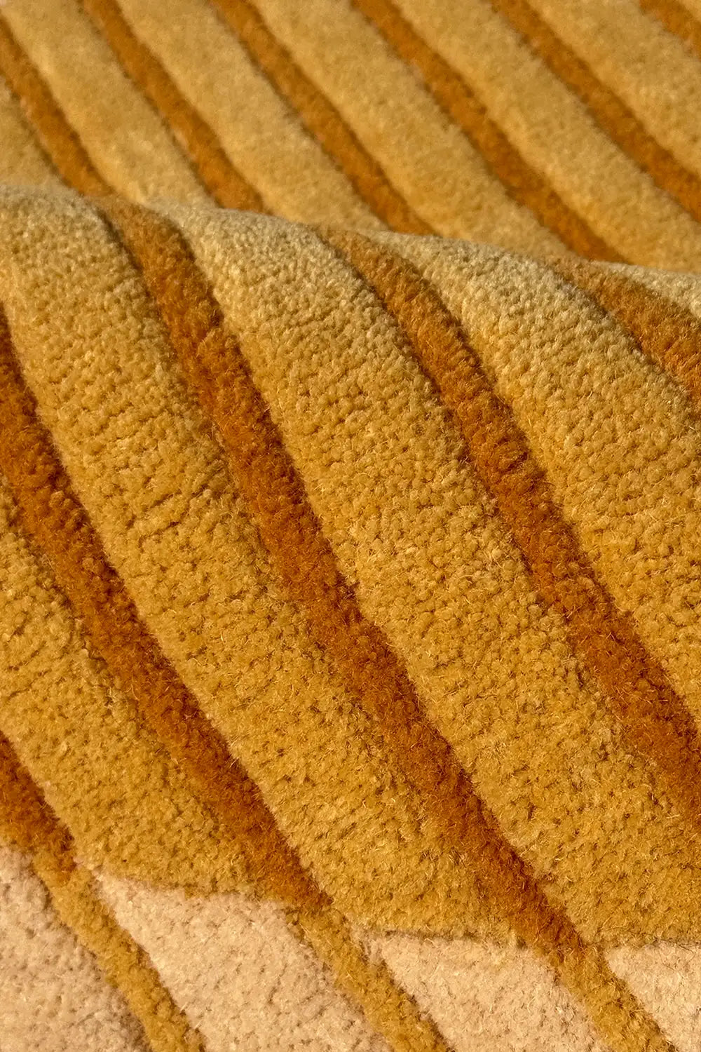 Close-up of textured yellow and tan wool rug fabric with modern graphic stripes
