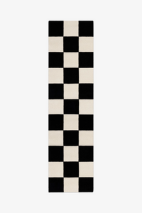 Checkered black and white runner rug on a white background