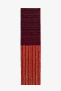 Two-tone red and burgundy textured runner rug on a white background