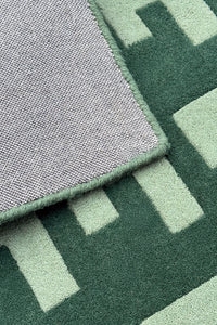 Close-up of a green wool runner rug with geometric patterns