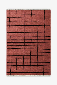 rust wool rug with a black grid pattern on a white background