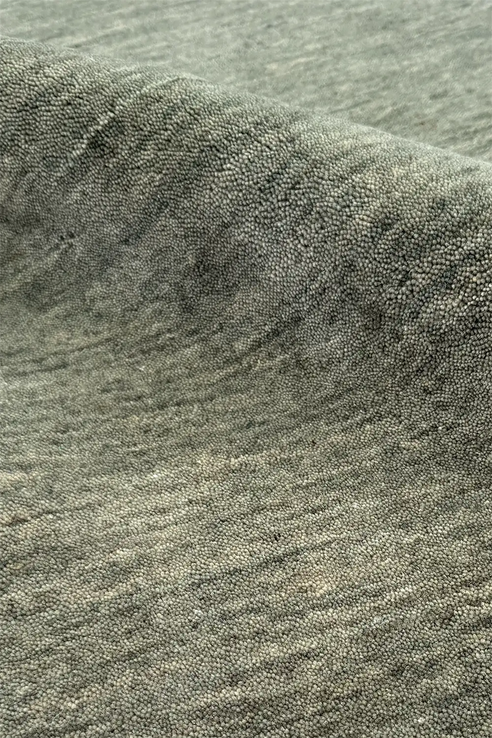 Close-up of textured sage green modern wool area rug