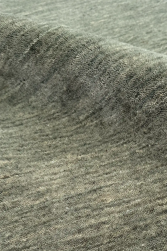 Close-up of textured sage green modern wool area rug