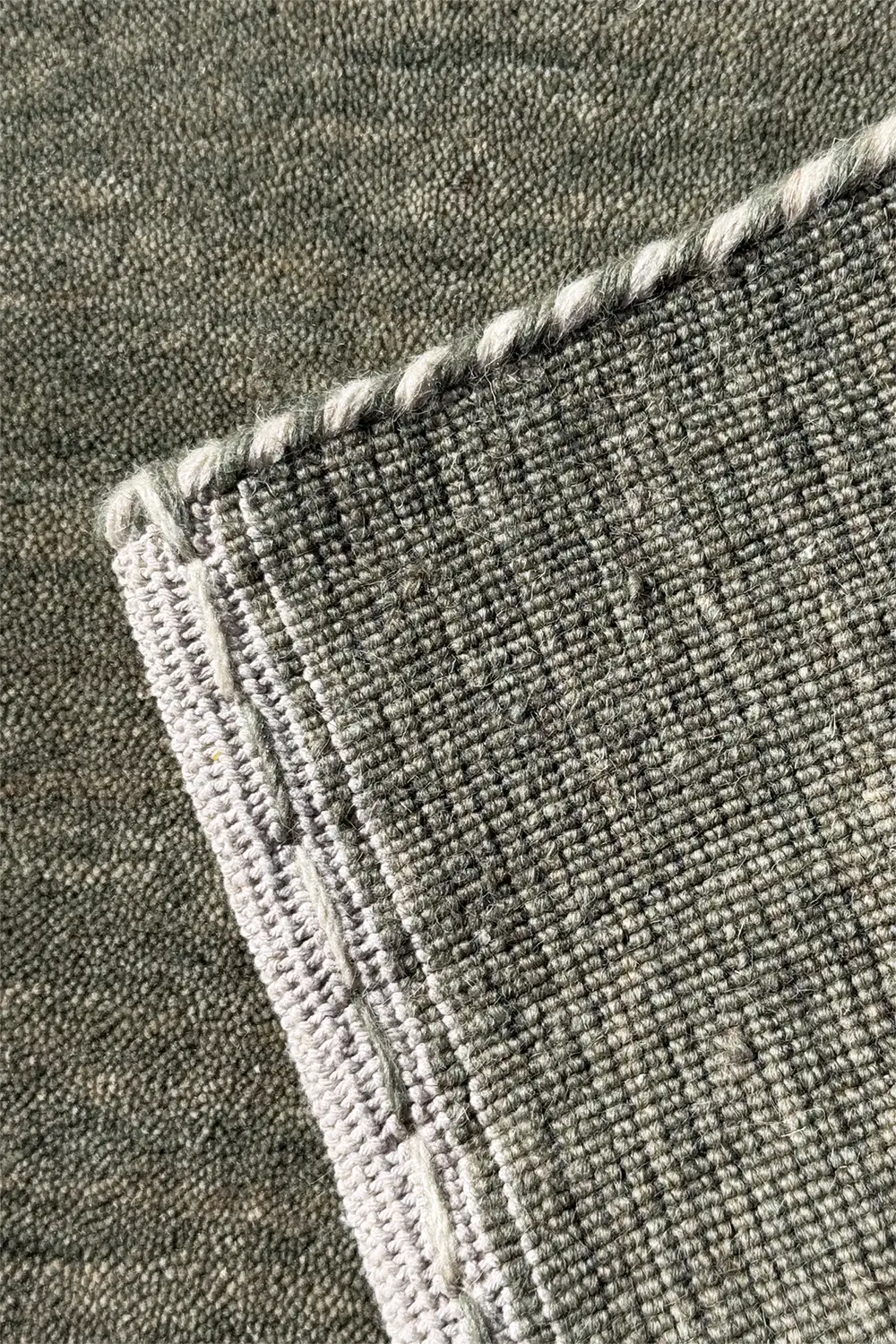 Close-up of a textured sage green carpet corner