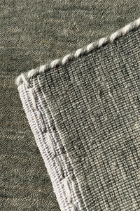 Close-up of a textured sage green carpet corner