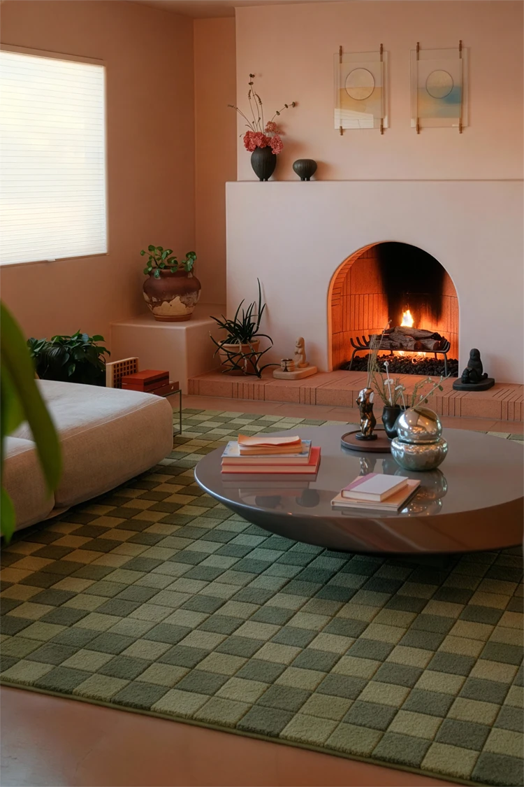 Living room with a fireplace, green checkered rug, coffee table, and decorative items.