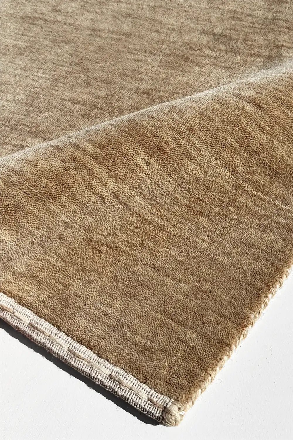Close-up of a light brown textured rug on a white background